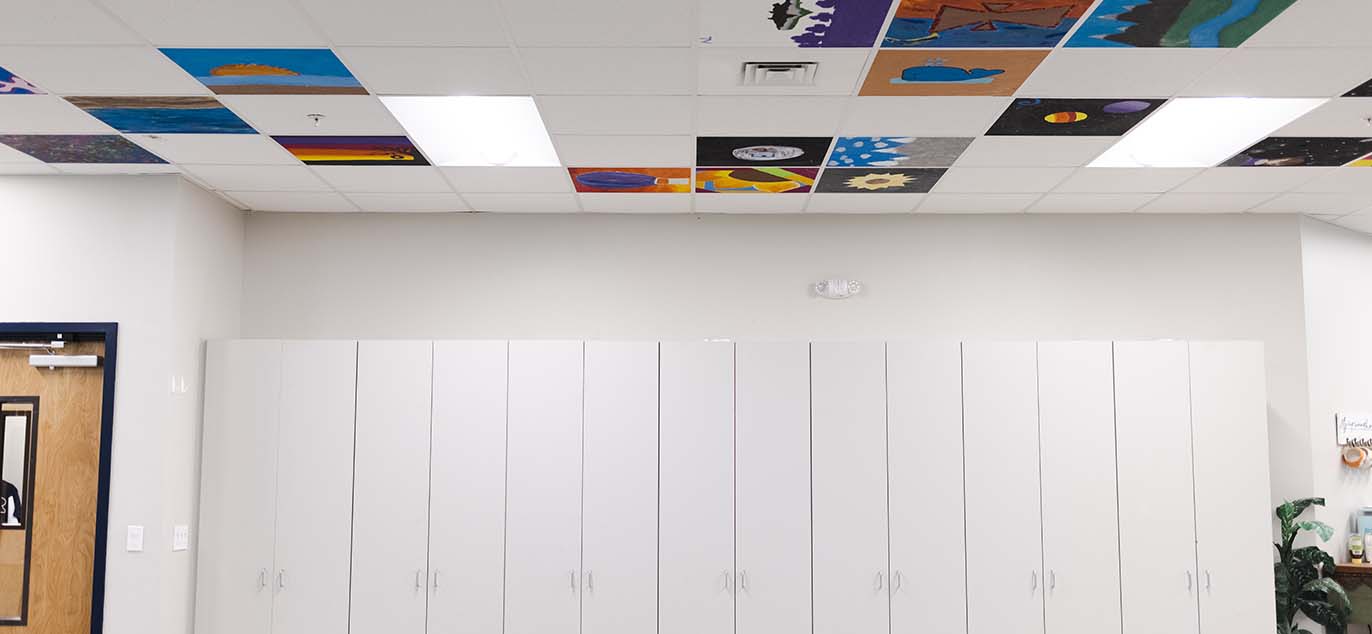 View of colorful ceiling tiles and white cabinets